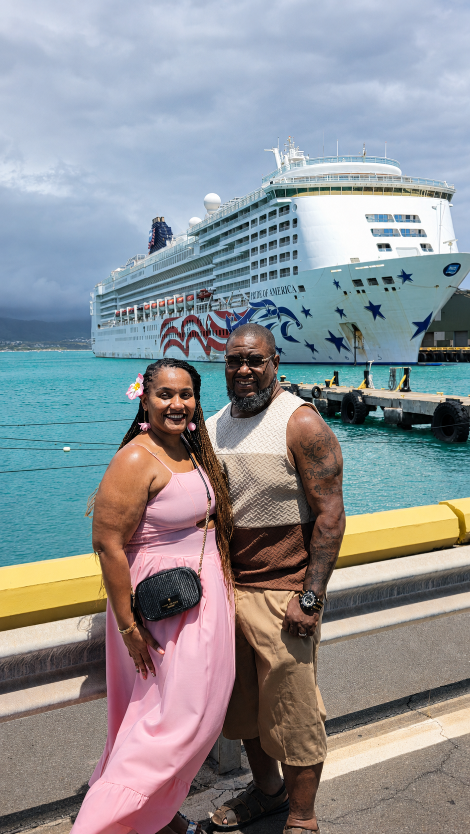 Leslie and her husband smiling in front of the Pride of America cruise ship in Hawaii