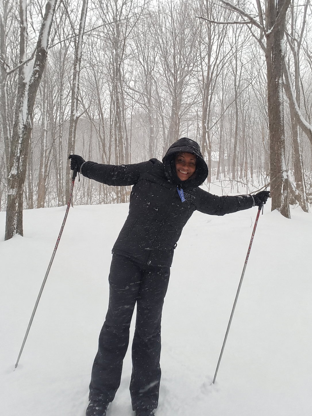 Leslie enjoying a snowy forest adventure with ski poles
