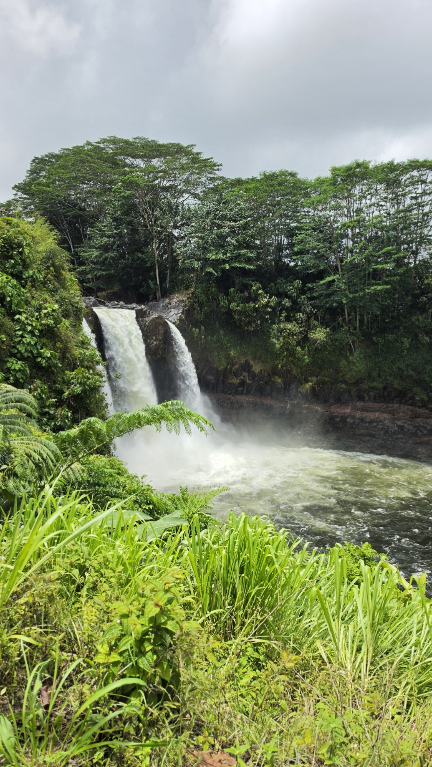 Rainbow Falls surrounded by lush tropical greenery